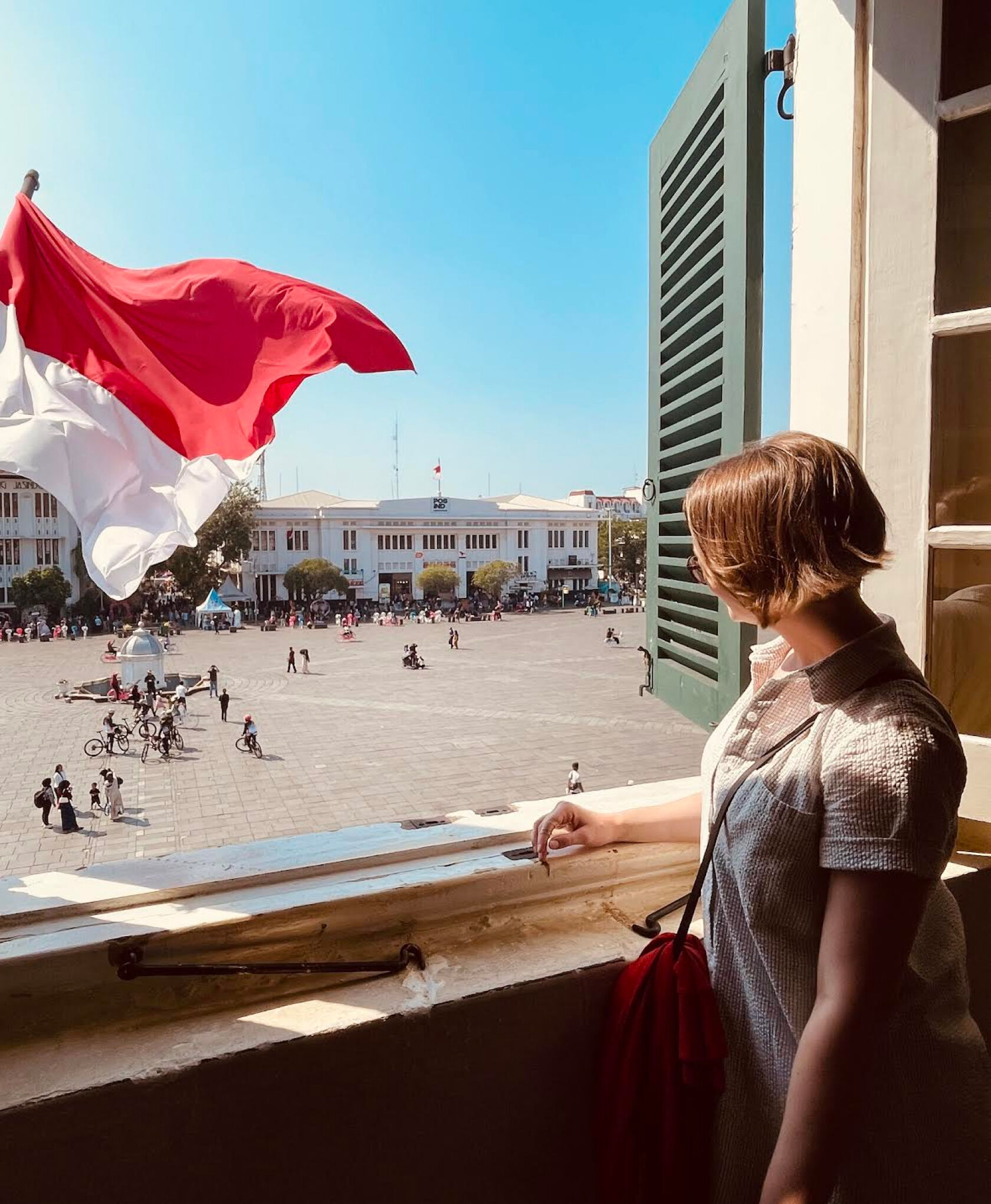 Woman looking out window in Kota Tua, Indonesia
