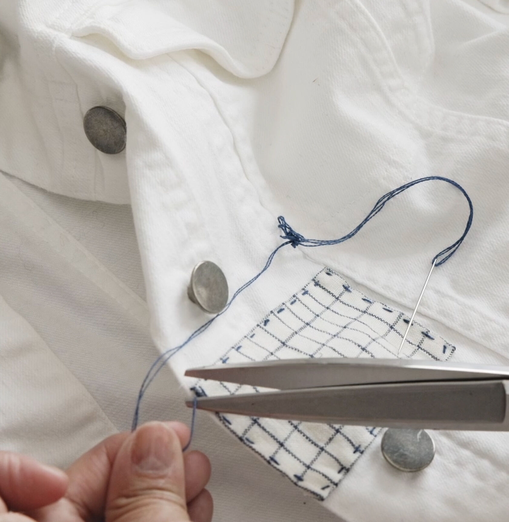 Trimming excess thread with scissors.