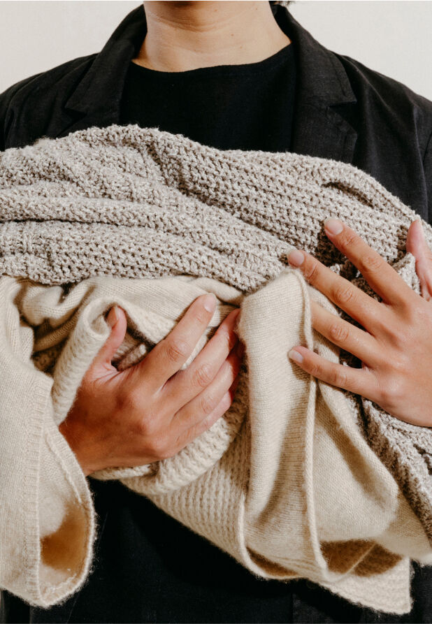 A woman holding clothes from EILEEN FISHER's take-back program, Renew.