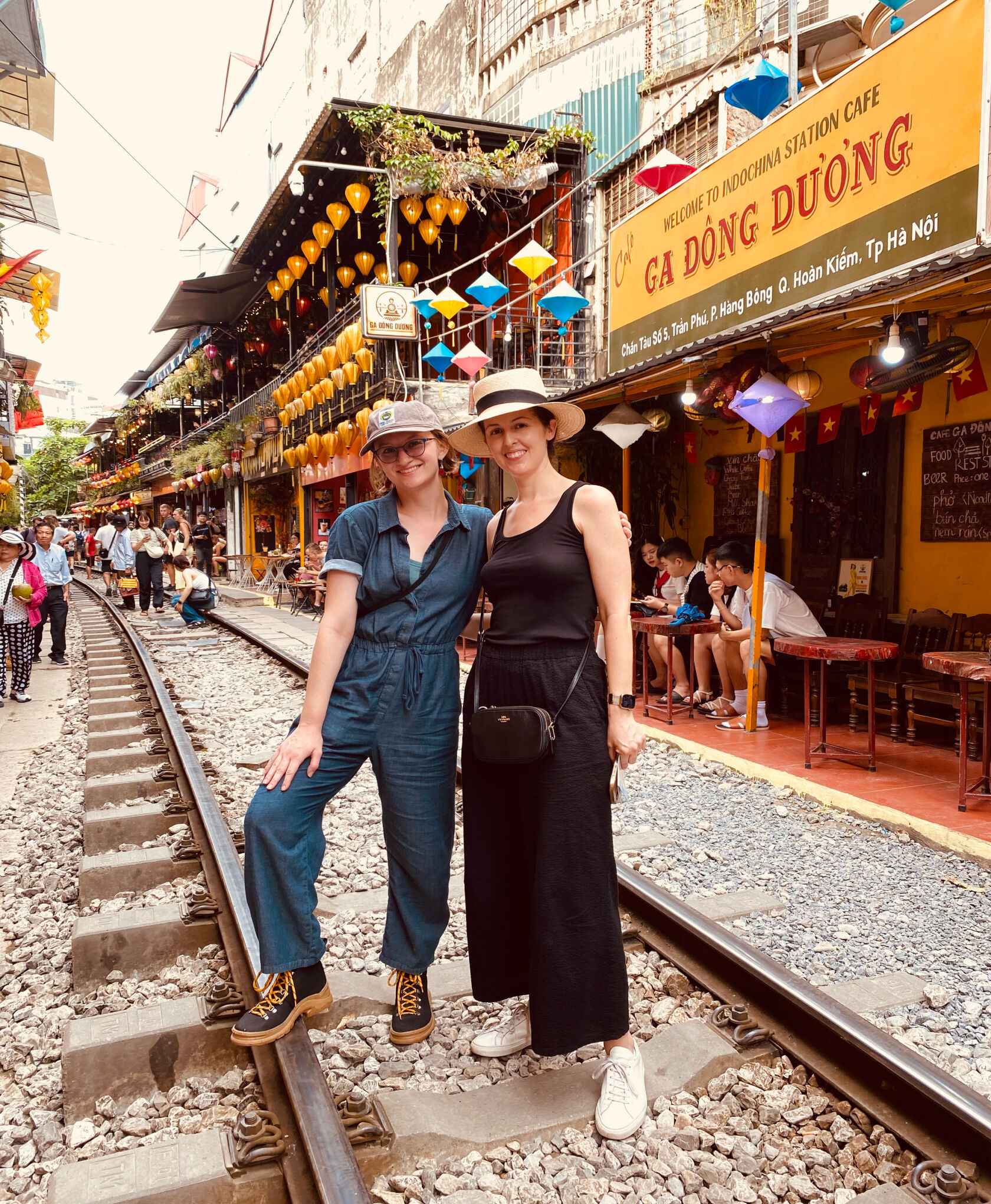 Two women posing at Train Street, a narrow alleyway in Hanoi.